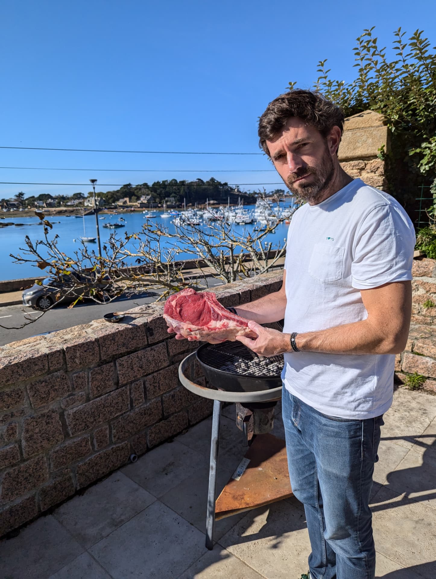 Un chef improvisé présente une côte de bœuf devant le port